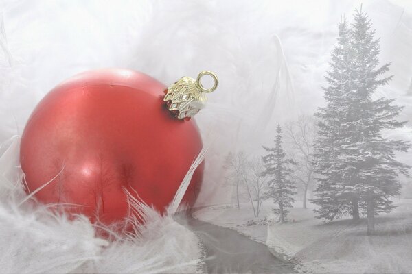 Красный ёлочный шар на фоне зимнего леса