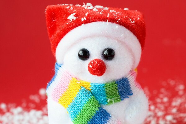Año nuevo fondo rojo muñeco de nieve recuerdo en uniforme y bufanda en la nieve artificial