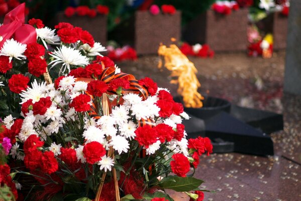 Flamme éternelle avec un panier de fleurs au premier plan