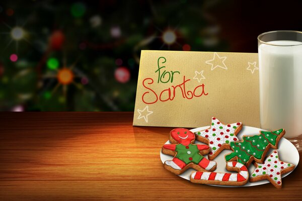 Galletas de Navidad en un plato blanco, un vaso de leche y una nota para Santa en una mesa de madera contra un árbol de Navidad