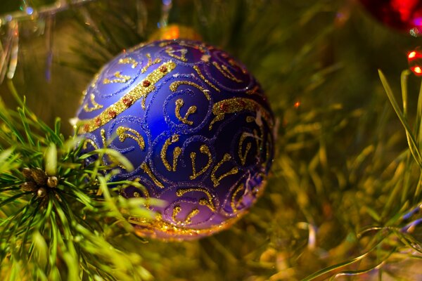 Blaues Weihnachtsbaum-Spielzeug mit goldenem Muster wiegt am Weihnachtsbaum