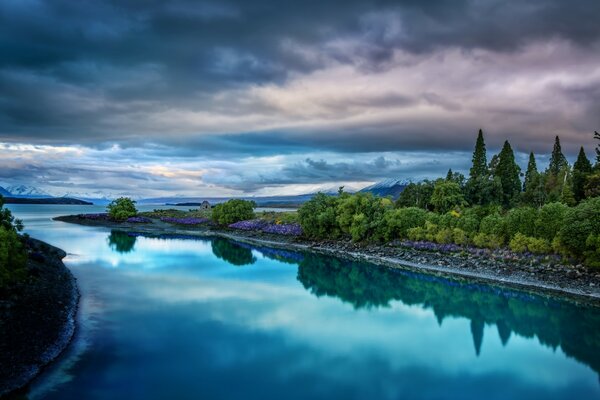 Bewölkte Wolken und Flussufer