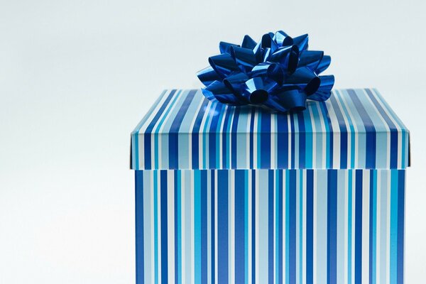 Caja de regalo con estilo. Rayas azul-blanco-azul en la Caja. Gran arco azul. feliz Año