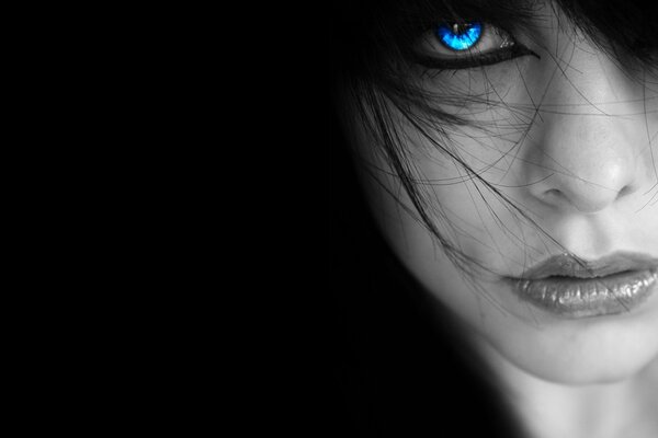 A woman s face with blue eyes in the dark