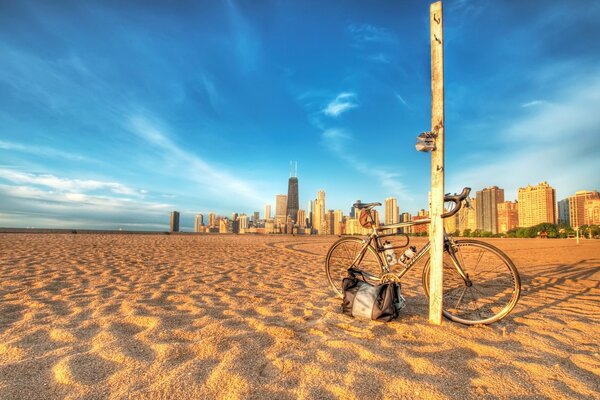 La playa, sobre ella un poste contra el que se apoya una bicicleta