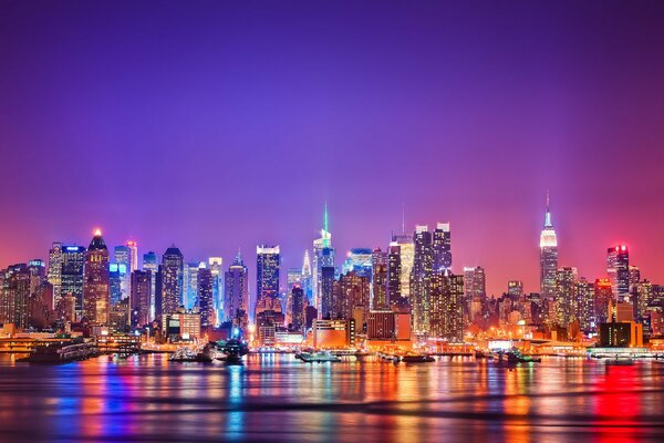 Les lumières de la nuit de Manhattan se reflètent dans la rivière Hudson