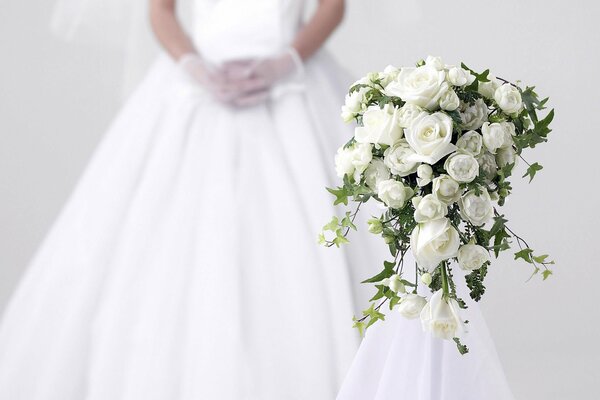 Wedding bouquet and dress in the background