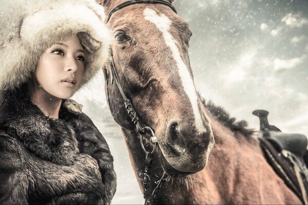 Beautiful girl on the background of snow and horses