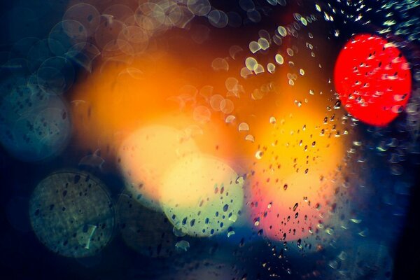 Rain splashes against the background of city lights