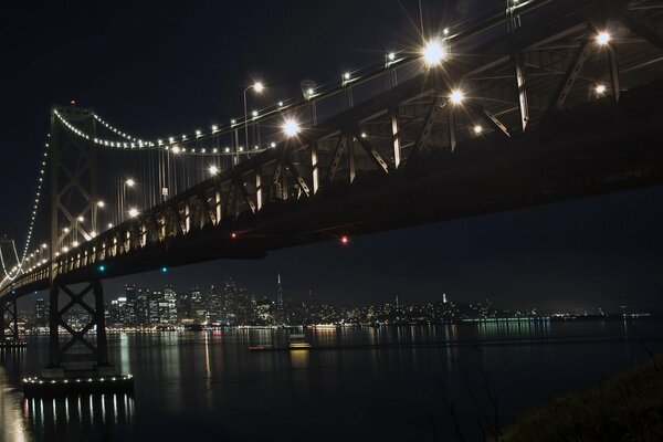 Les lumières de la nuit sur le pont se reflètent dans la rivière