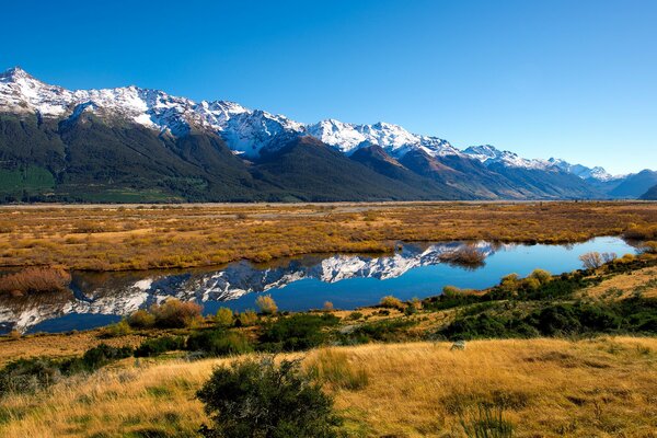 Le lac de steppe et les montagnes enneigées y sont reflétées