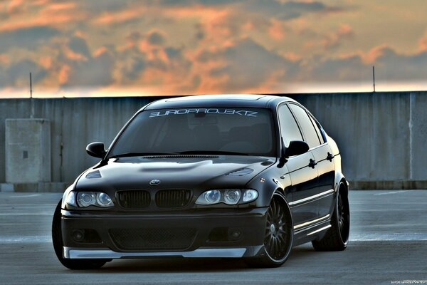 Black BMW on the roof of a skyscraper