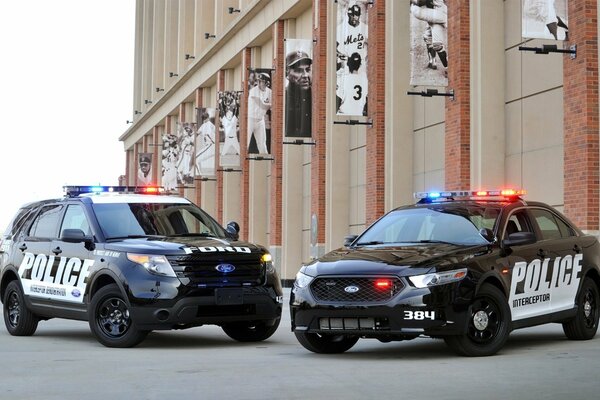 Two ford police interceptor cars near the stadium