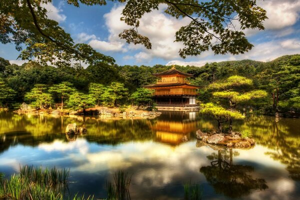 Das Gold der Pagoden des japanischen Tempels spiegelt sich in Gewässern und Wolken wider