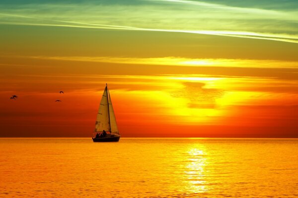 Y navegó un velero en una puesta de sol naranja