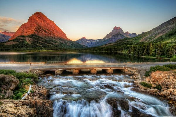 Natur mit Fluss und Brücke bei Sonnenaufgang