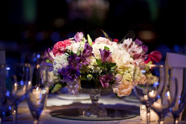 The composition on the table is decorated with flowers