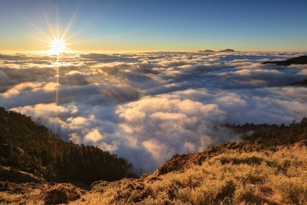 Le soleil brille sur les nuages et les montagnes