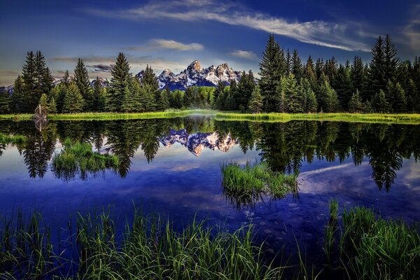 Montagnes rocheuses et paysage forestier reflète la profondeur des eaux bleues du lac