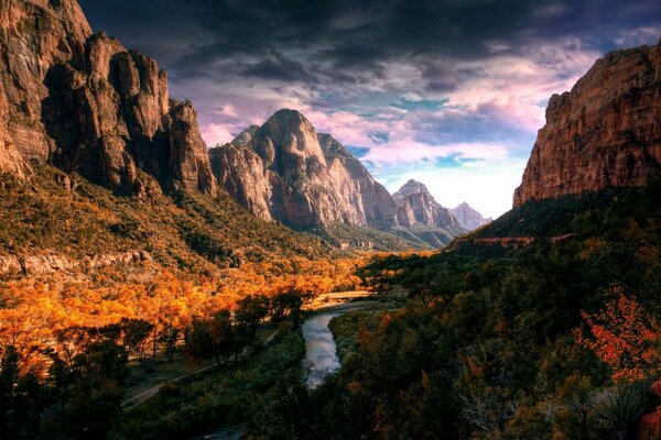 Paesaggio con foresta gialla, fiume e montagne