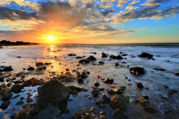 Sea with rocks on the background of sunset