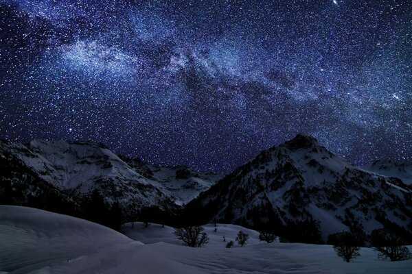 Enchanting night starry sky and winter mountains