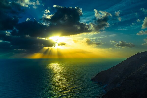 Sonnenuntergang am Meer zwischen Bergen und Felsen