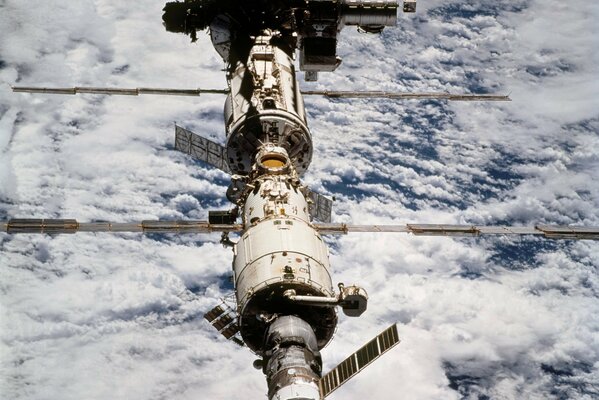 ISS sullo sfondo di una terra trascinata dalle nuvole