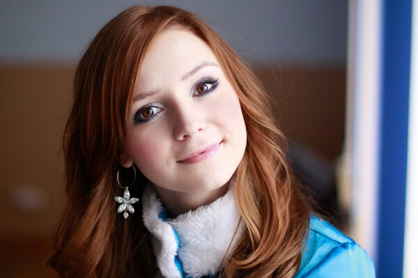 Beautiful red-haired girl looks into the blue distance