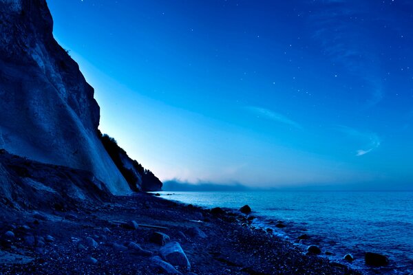 Riva del mare vicino alle colline al chiaro di luna