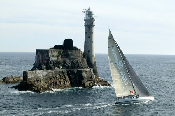 Sailboat at the lighthouse and rocks