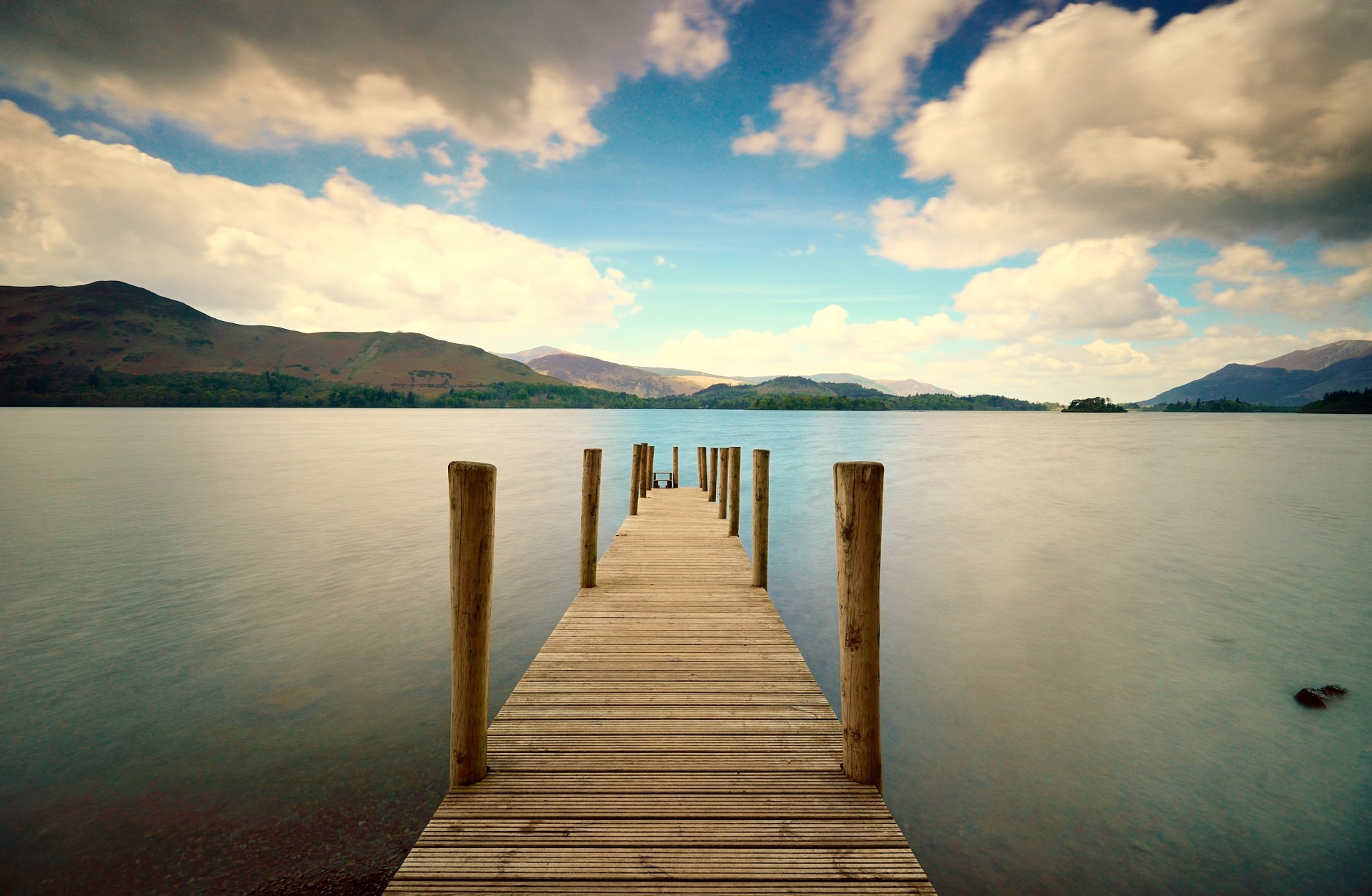 hill foliage widescreen full screen green pier nature board bridge hills wallpaper water sky sea background clouds tree