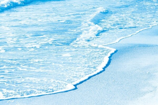 Azure foamy wave on blue sand