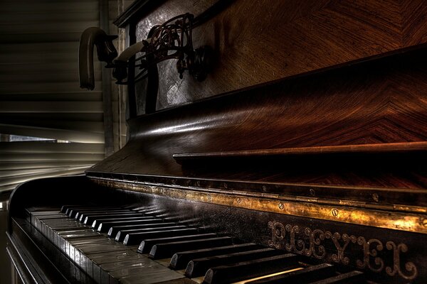 Close-up of an old wooden piano in a dark room