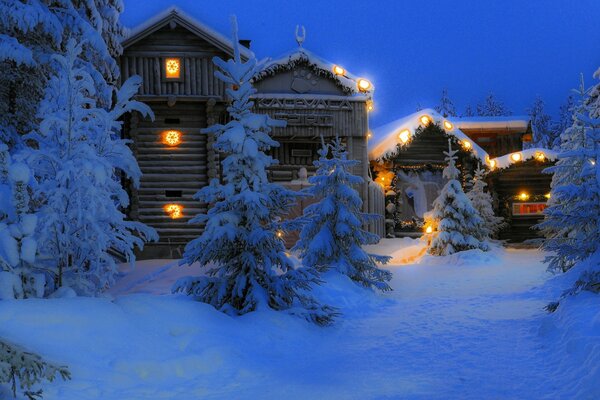 Case in legno nella foresta invernale