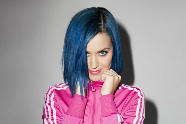 La cantante Katy Perry indossa una tuta rosa con i capelli blu brillante