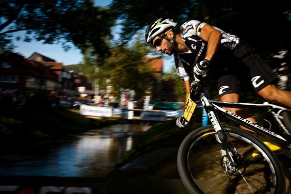 Il ciclista ricicla il fiume attraverso il ponte