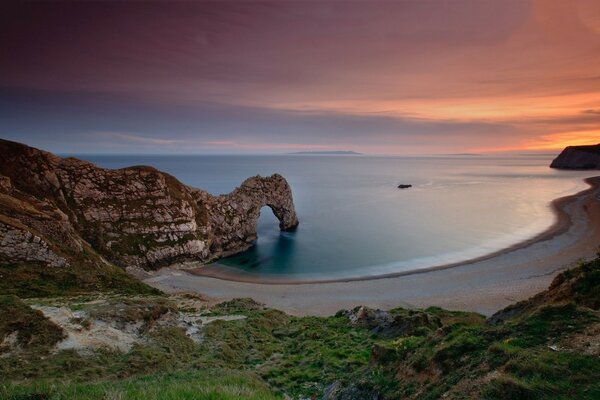 Bord de mer au coucher du soleil. Plage sableuse