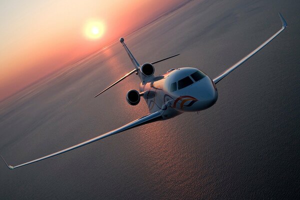 Das Flugzeug fliegt über das Meer. Schöner Sonnenuntergang