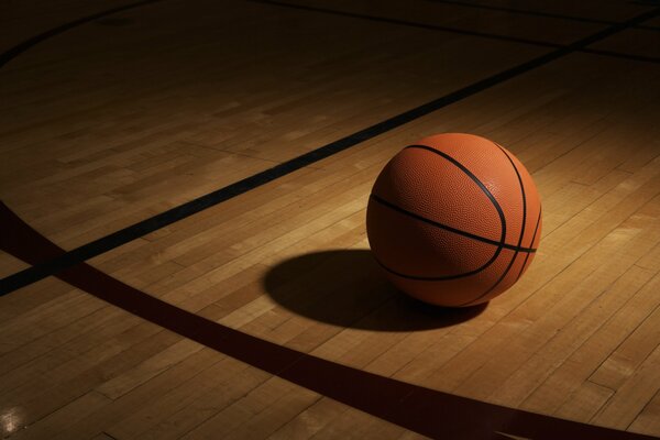 Ballon de basket dans l ombre sur le sol