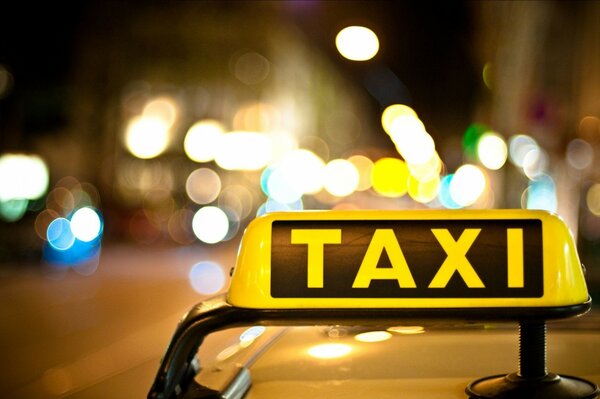 Black and yellow checker taxi on the roof of the car