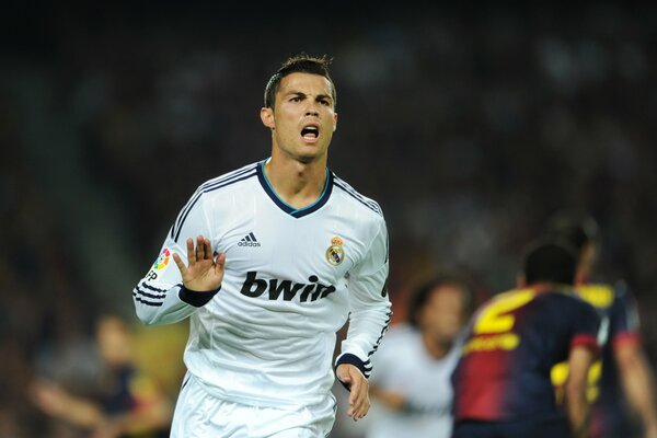 A football player runs after a playful ball