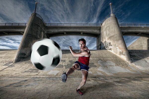 Athlete with a ball on the background of the bridge