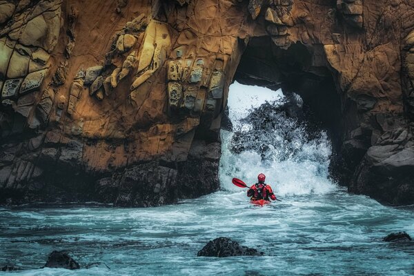 Atleta rafting en un bote a través de las rocas