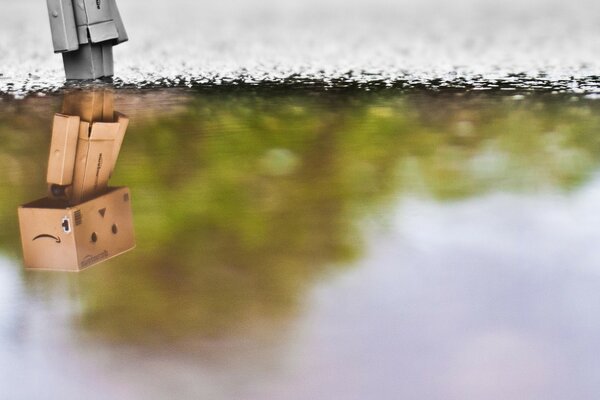 Reflexion eines kleinen Roboters im Wasser