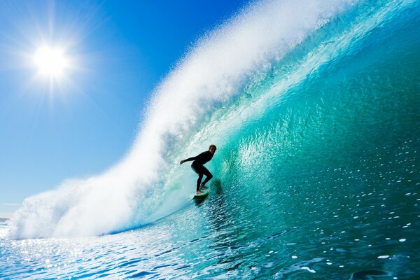 A man on a board on a blue wave in the ocean