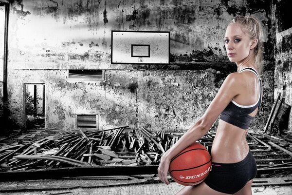 Mädchen mit einem Basketball auf einem düsteren Hintergrund