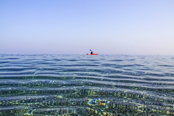 A man in a canoe swims in the sea