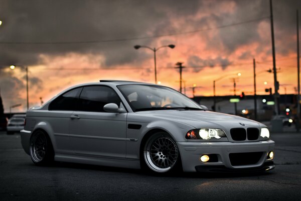BMW blanco en el fondo de la puesta de sol