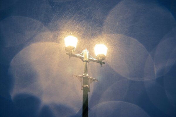 Night lantern during snow on dark sky
